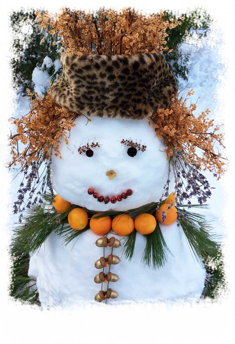 Winter snow beauty made of snow with a leopard print headband and natural materials to create hair and features.